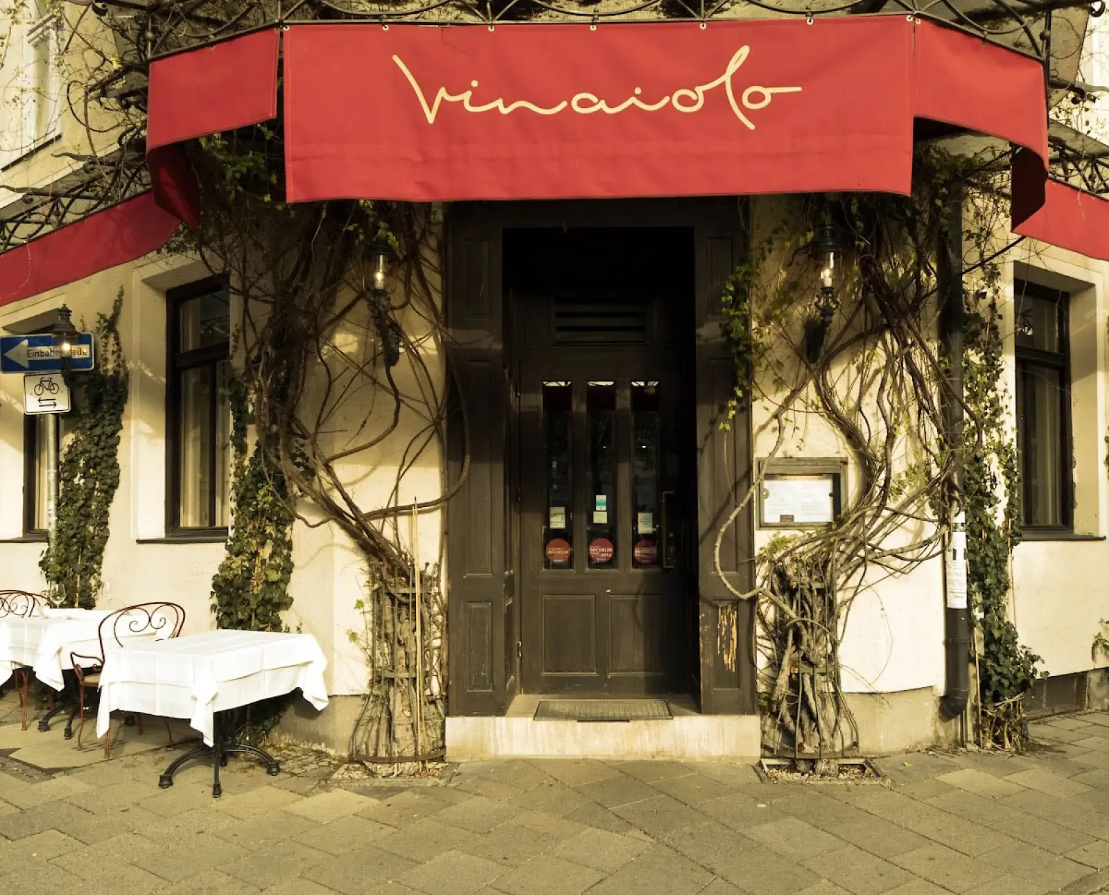Gemütliche Weinbar in München mit warmem Licht und kleinen Tischen