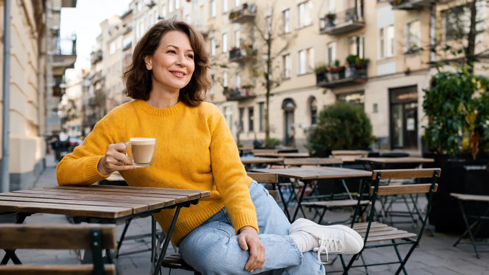 Menschen sitzen an einem sonnigen Tag in einem Berliner Straßencafé